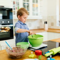 Child helping mother make cookies as a professional chef