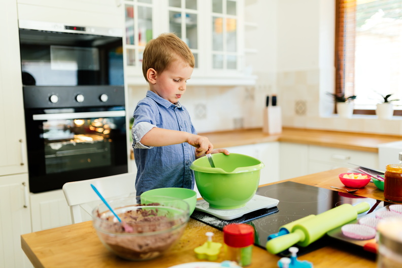 Child helping mother make cookies as a professional chef