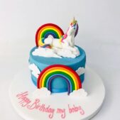 Unicorn themed birthday cake with rainbows and clouds