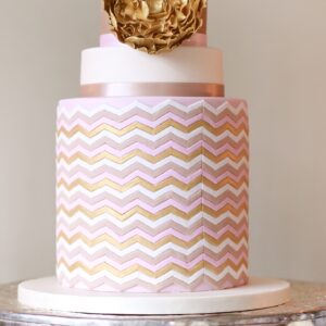 gold rose cake on silver stand and candle vertical